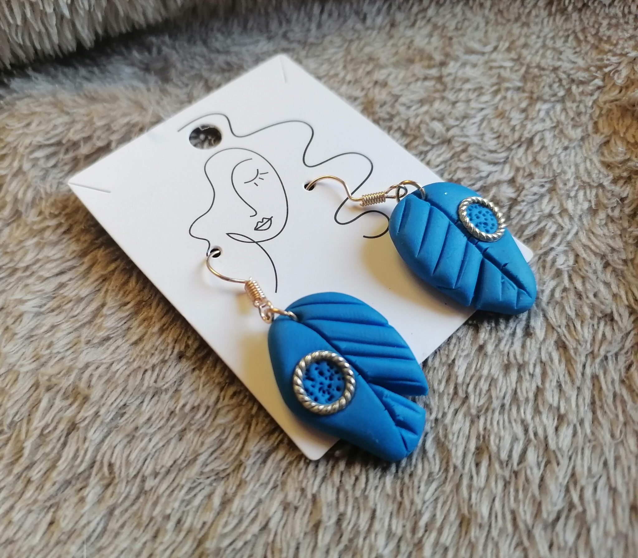 Blue feather earrings from the side